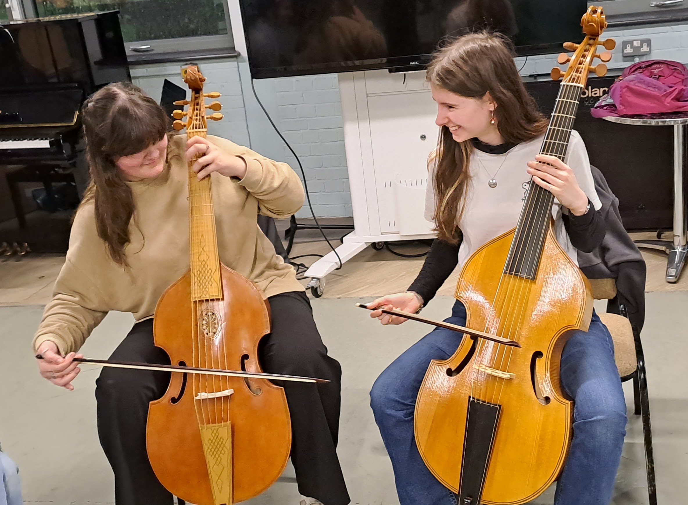 Two members of the baroque ensemble trying out bass viols