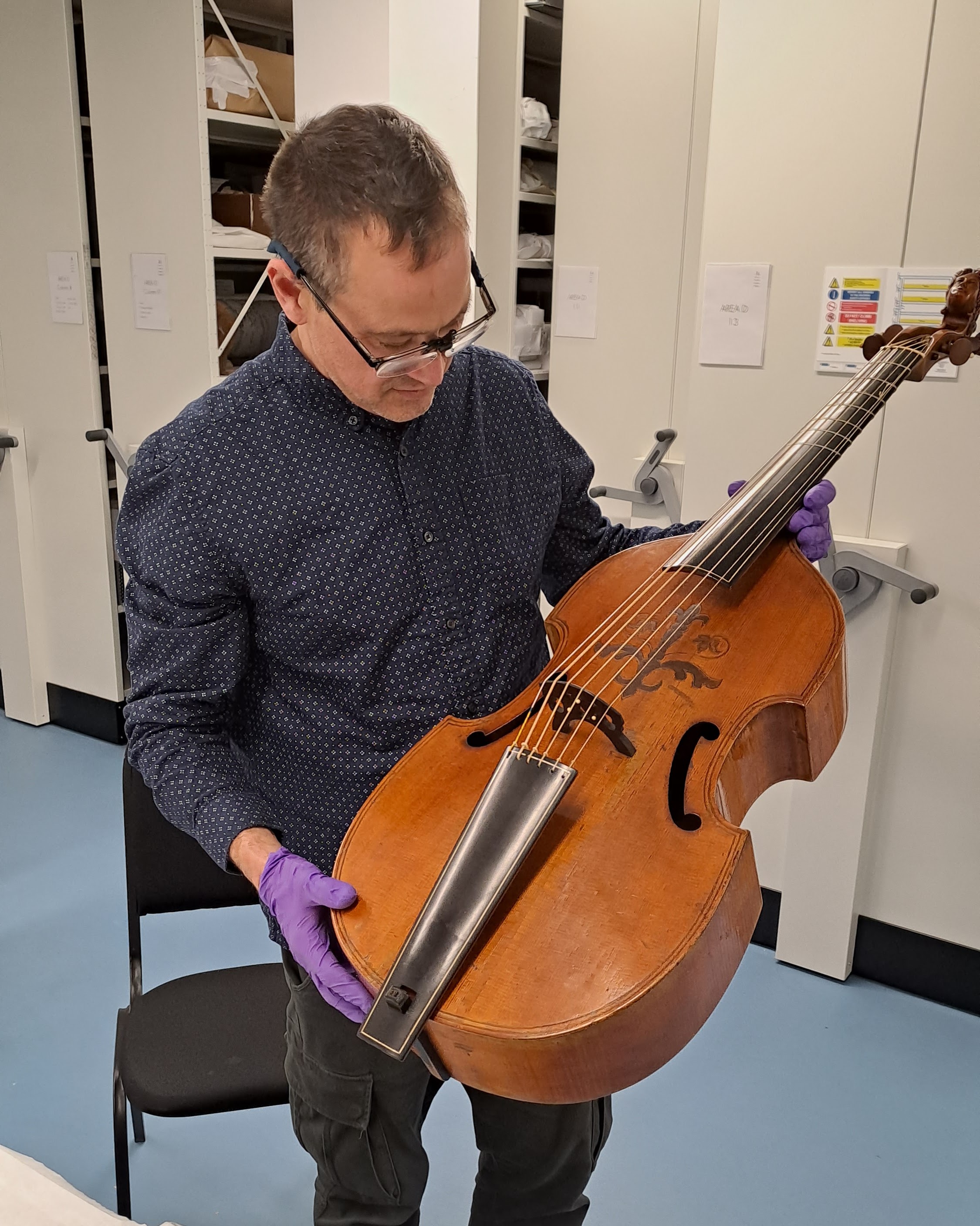 Paul examining a 1660 Meares bass viol at the Royal College of Music